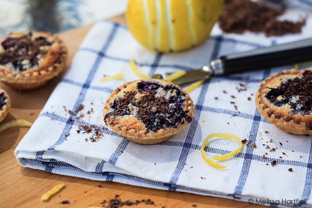 blueberry coconut tarts with lemon zest and chocolate shavings